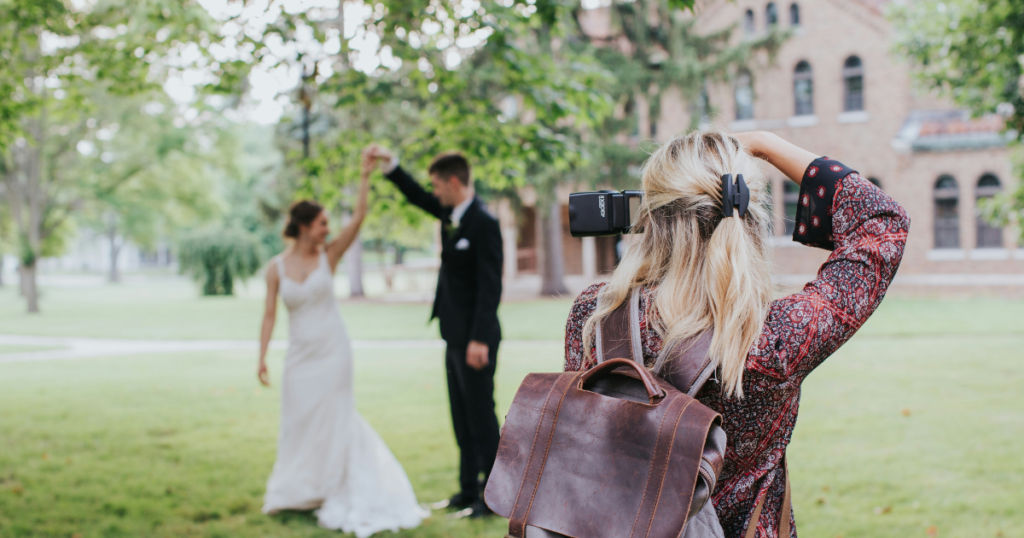 Photo showing a wedding photographer capturing a wedding couple outdoors.